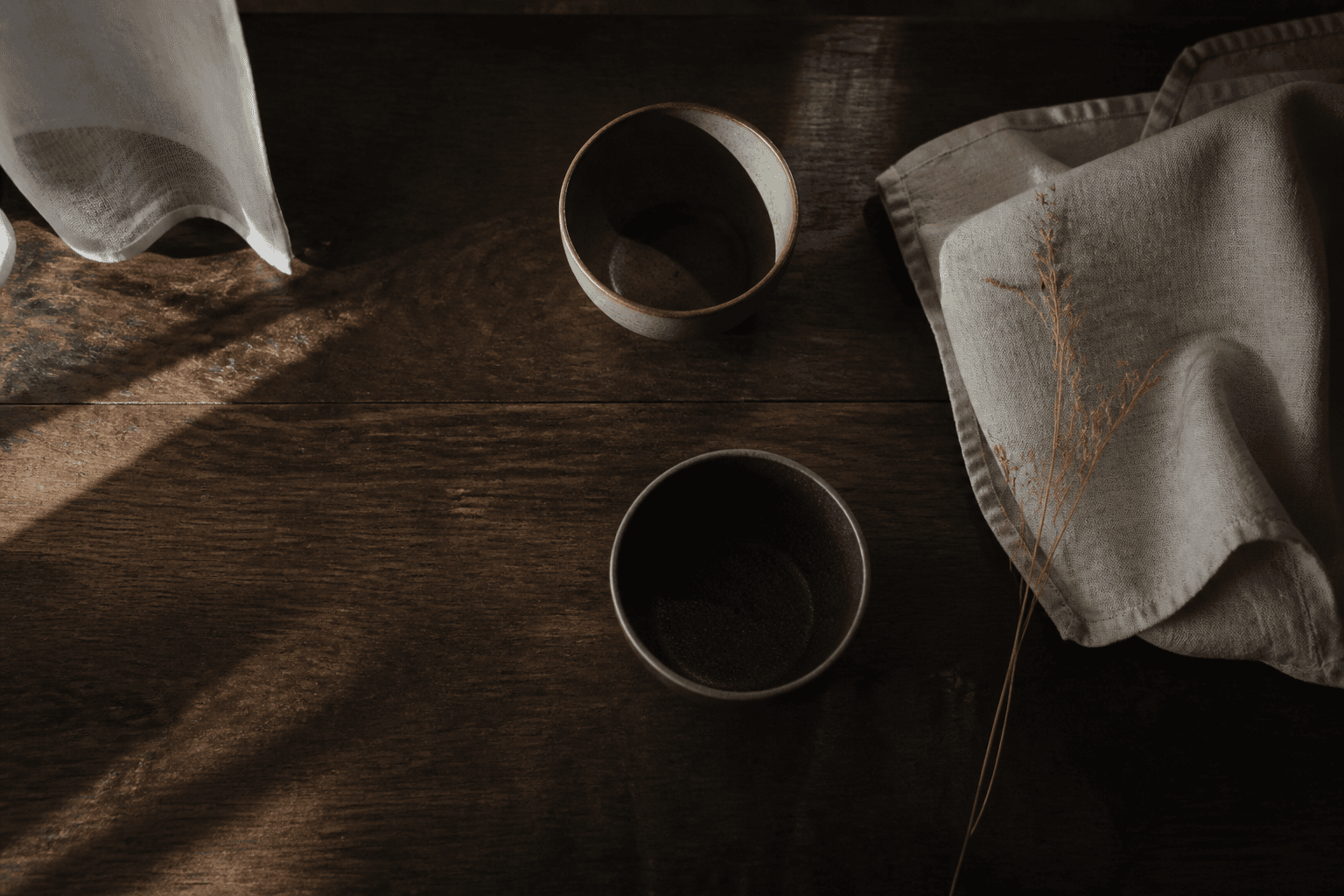 Two cups on a dark table in morning light. Placeholder still.
